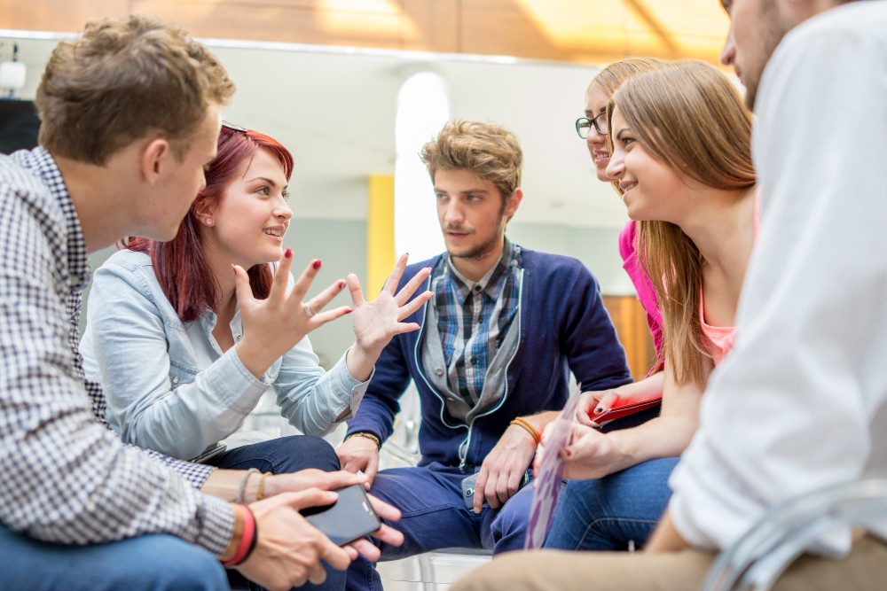 Image of a diverse group of friends laughing while having a discussion